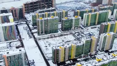 鸟瞰现代城市的高楼大厦，停放和移动汽车沿街道覆盖的雪。 动作。 城市