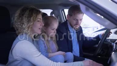 汽车生意，快乐的微笑爸爸妈妈和小女孩回顾家庭汽车挥舞钥匙和拇指，同时