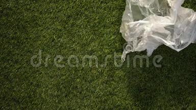 风卷塑料包装在草地上，对地球的危险责任