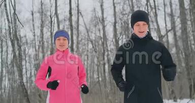 冬天，一男一女穿着粉红色夹克，慢悠悠地穿过公园。 健康生活方式