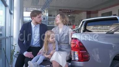 汽车店，女儿幸福家庭的画像，选择汽车，坐在后备箱里互相咨询