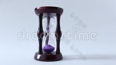 玻璃，沙漏或鸡蛋计时器在白色背景与紫砂显示几乎结束的时间或时间