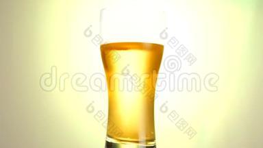 轻啤酒特写.. 冷光啤酒在哑光黄色背景上分离，在白色背景上旋转。