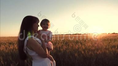 快乐的<strong>妈妈</strong>把她的小女儿抱在<strong>怀里</strong>，抱在美丽的夕阳下的一片麦田上。 幸福家庭