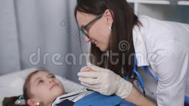 微笑友好的女医生与躺在医院病床上的儿科医生`办公室里的小病人交谈