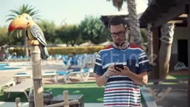 商人正在智能<strong>手机</strong>上阅读<strong>电子</strong>邮件，在酒店度假时散步