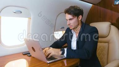 年轻的商人在私人飞机上用笔记本电脑工作。 成功的商业百万人<strong>头等</strong>舱旅行