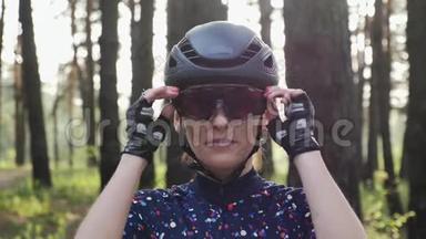 年轻漂亮的女孩戴上自行车眼镜，戴着头盔和蓝色球衣。 公路自行车概念。