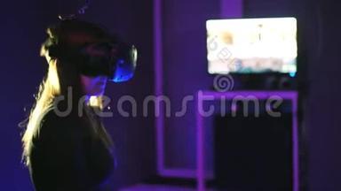 女人玩3D虚拟现实游戏。 在射击<strong>VR</strong>游戏中使用控制器射击。 女孩戴着<strong>VR</strong>耳机。 监测器