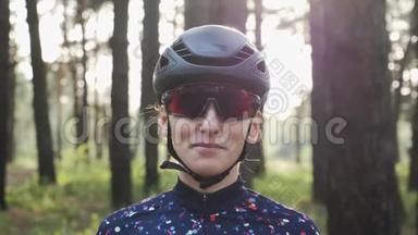 漂亮的年轻白种人女人戴着黑色头盔和运动衫，戴上自行车眼镜。 铁人三项的概念.. 慢动作