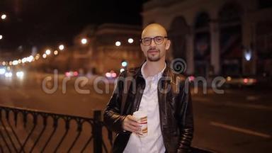 一个男人在夜里从巷道里拿着一杯咖啡的画像。 夜间商业生活