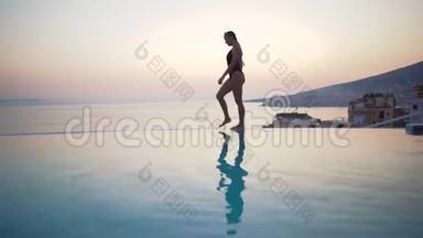 夏天美丽的比基尼女人。 比基尼女孩走在夏天的游泳池海滩。 在热带放松。 度假的概念