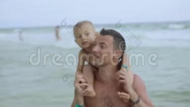 年轻的<strong>父亲和</strong>他的小<strong>儿子在</strong>海滩上玩得很开心。 <strong>儿子</strong>坐<strong>在</strong>爸爸`肩膀上