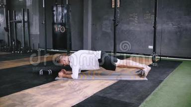 强壮的男人做木板锯，在健身房锻炼。