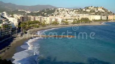 4K电影无人机顶景视频片段拍摄的西班牙海岸城市，而绿松石海浪在沙地上破碎