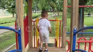 镜头跟随<strong>幼儿</strong>滑下<strong>幼儿</strong>`游戏区.. 一个快乐的小男孩在孩子们`公园里玩耍