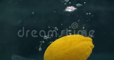 几个柠檬水果掉进水箱里，扰乱了水。 三个亮黄色柠檬水果倒在水里