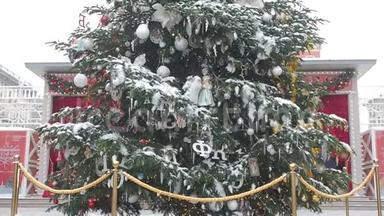 镜头从下到上移动，重点放在覆盖着雪和美丽装饰的大圣诞树上