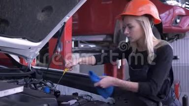 汽车车间，幸福女工汽车修理工在汽车维修期间用敞篷罩检查油位
