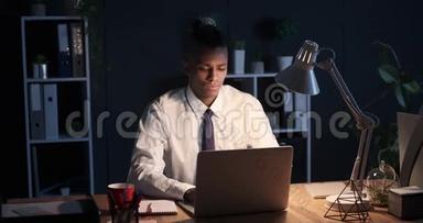 商人在深夜喝咖啡，在笔记本电脑上工作
