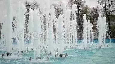 小镇中心有几条高高的喷泉。 游泳池的蓝色水。 晴天，市中心天气温暖