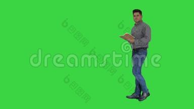 男经理正式穿着，拿着记事本走路，做笔记，环顾绿色屏幕，Chroma键。
