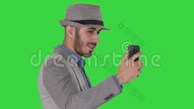 阿拉伯魅力男子穿着休闲服装录制视频博客绿色屏幕，Chroma键。