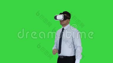 商人在VR眼镜和与虚拟现实对象互动的绿色屏幕，Chroma键。