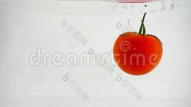 一个成熟的红番茄，右边是白色的背景，在水中旋转