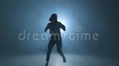 运动现代风格的嘻哈舞者展示他的<strong>舞蹈</strong>蓝色工作室<strong>背景</strong>，慢动作。