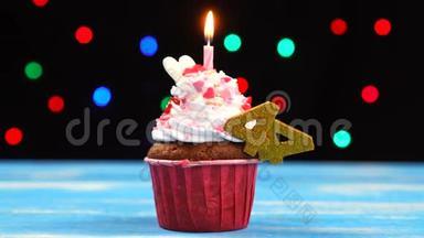 带有蜡烛的美味生日蛋糕和44号的彩色模糊灯光背景