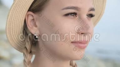 一个漂亮的白种人年轻女子戴着一顶草帽、扎着辫子的大特写肖像，使帽子挺直