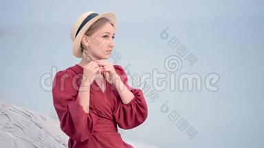一位穿着红色连衣裙，戴着一顶辫子草帽的白种人年轻女子，坐在上面，她的肖像很吸引人