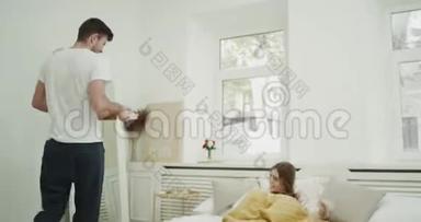 年轻人把早餐带给他的女朋友，完美的早晨在舒适的卧室。