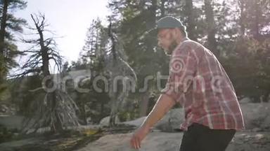 镜头跟随年轻快乐的英<strong>俊男</strong>子独自徒步，看着相机在美丽的约塞米蒂国家公园慢动作。