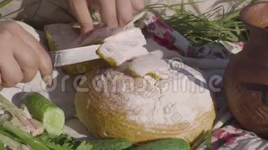 一个年轻女人在白面包上切猪油的特写。 健康食品，乌克兰传统美食