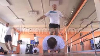 在一个现代化的健身中心，一组双打的白种人男子进行跳跃运动以减肥和促进健康