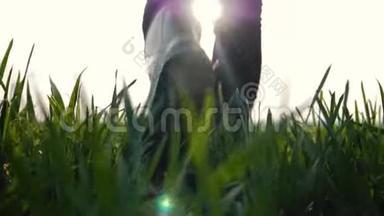 在夕阳的照耀下，女<strong>农民</strong>穿着橡胶靴在绿色的田野上行走。 农业<strong>耕作</strong>