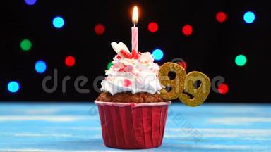 带有蜡烛的美味生日蛋糕和<strong>99</strong>号的彩色模糊灯光背景
