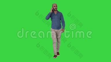 年轻的阿拉伯男人在电话里<strong>走来走去</strong>，在绿色的屏幕<strong>上</strong>微笑，铬钥匙。