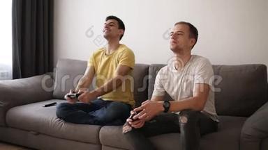 两个<strong>游戏</strong>玩家在玩完<strong>游戏</strong>后坐在沙发上。 穿黄色T恤的布鲁内特男人-<strong>胜利</strong>者在嘲笑