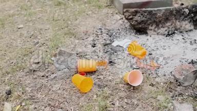 粗鲁的男人扔下橙色的塑料杯。 塑料污染