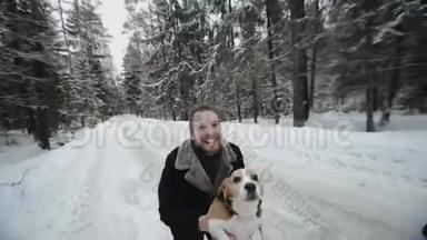 小猎犬和<strong>主人</strong>一起散步。 他为了好玩把<strong>宠物</strong>扔了。 人和狗在冬天的森林里玩得很开心。