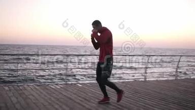 一个年<strong>轻</strong>的<strong>运动</strong>员慢跑的侧视镜头，在拳击训练前热身。 清晨