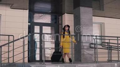 穿着黄色雨衣和帽子的漂亮女人走出酒店的<strong>门廊</strong>，摘下眼镜，环顾四周。