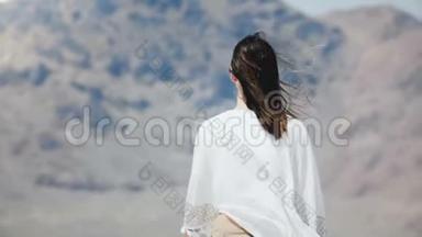 镜头跟随年轻快乐的女人，张开双臂，在阳光明媚的犹他州盐漠湖，头发在<strong>大风</strong>中吹起。