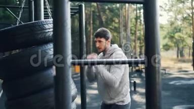 大胡子的家伙是一个人在户外拳击使用轮胎在运动场锻炼在<strong>夏季</strong>的一<strong>天</strong>。 锻炼身体