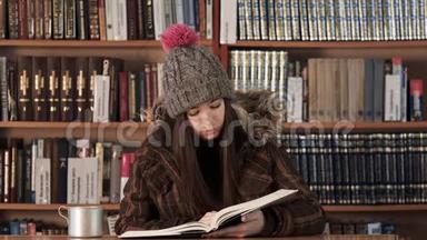 戴着冬帽的青少年在酒店大堂读课文