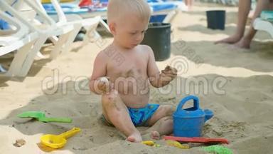 那个可爱的小男孩在海边玩沙子玩具。 孩子们在暑假在海滩度假。