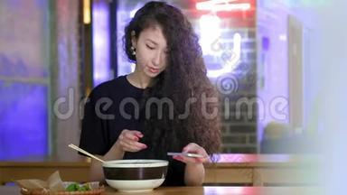 一个可爱的年轻亚洲女孩在亚洲咖啡馆的智能手机pho汤上拍照。 <strong>中文</strong>、越南文或<strong>日</strong>文